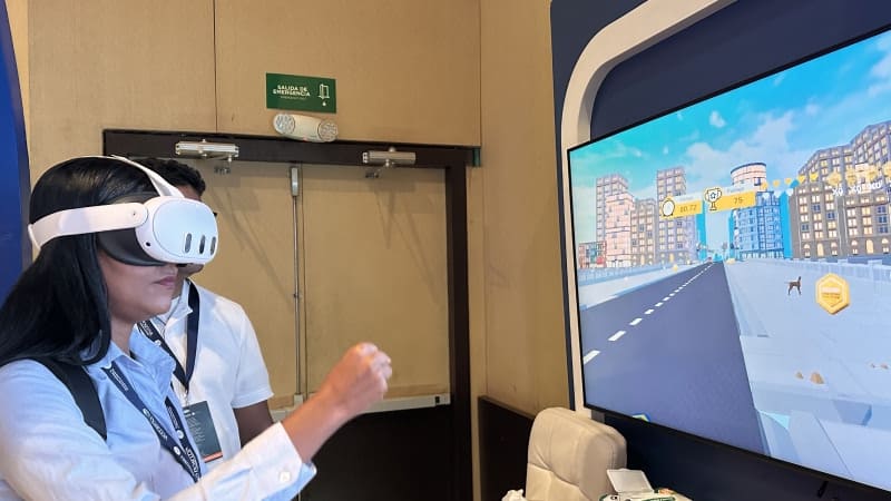 mujer jugando en el módulo interactivo de Colmena Seguros